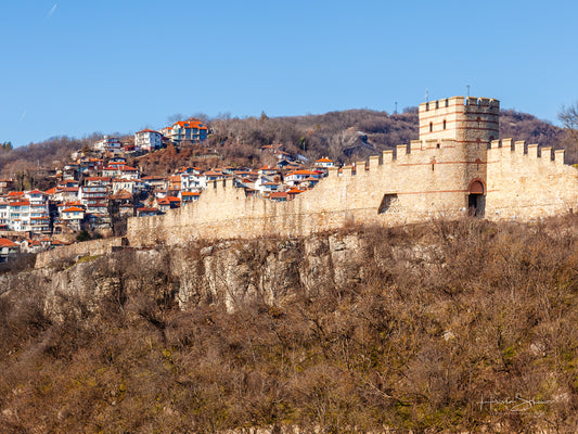 Tsarevets Fortress on a hill with a cloudy sky in the background