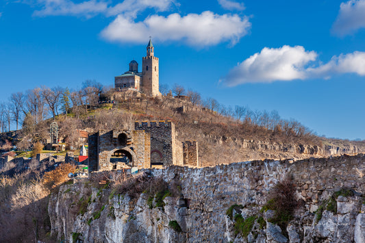 Tsarevets Fortress on a hill with a cloudy sky in the background