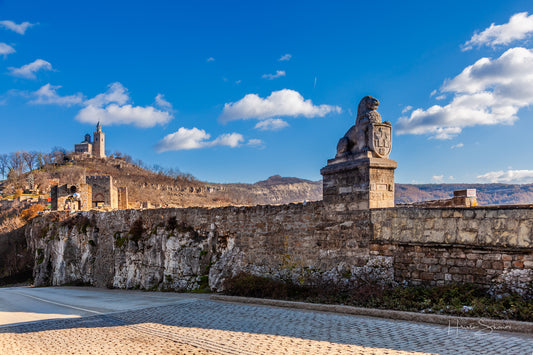 Tsarevets Fortress on a hill with a cloudy sky in the background