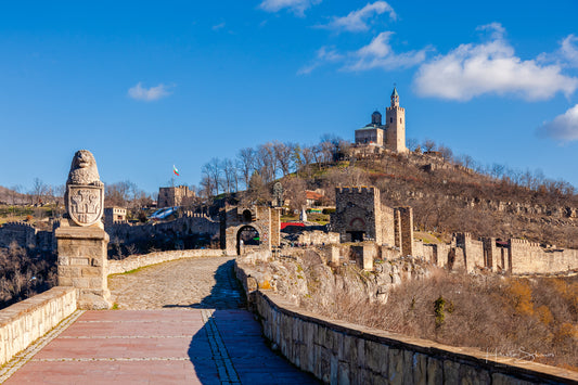 Tsarevets Fortress on a hill with a cloudy sky in the background
